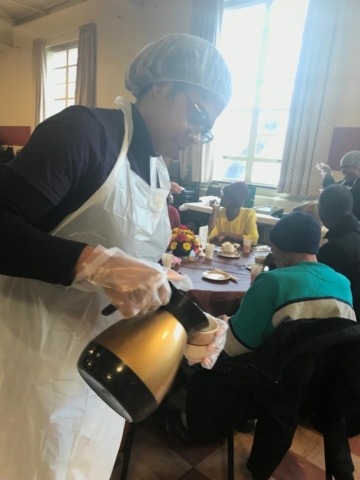 Woman in a hairnet serving hot drink