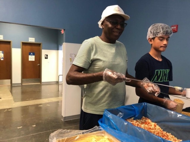 Volunteers scooping rations